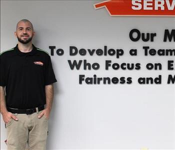 Tech standing in front of our mission statement