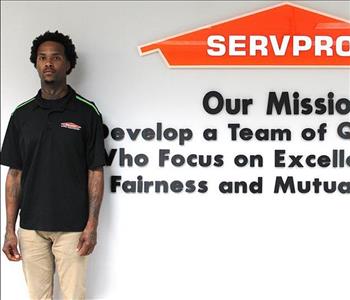 Tech standing in front of our mission statement